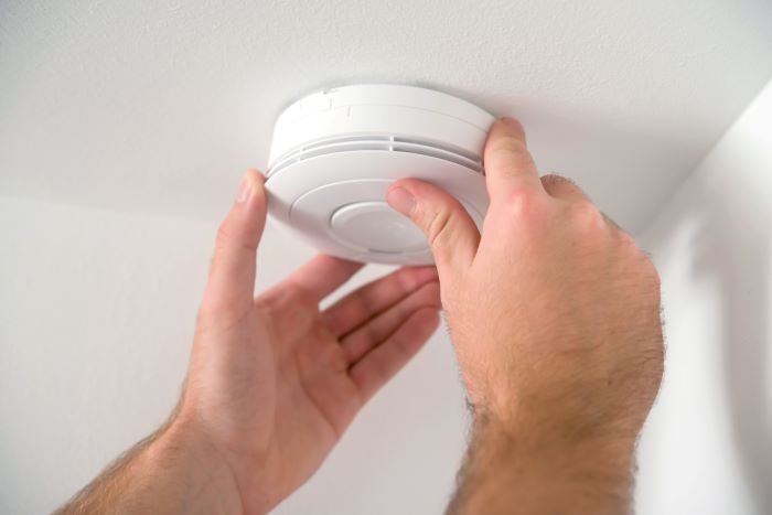 electrician installing smoke detector